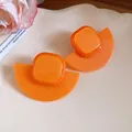 Detailed view of bright orange resin fan-shaped earrings with square accent - Orange