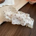 Gros plan d'une pince a cheveux en tissu avec motif floral et bordure en dentelle - Beige Floral