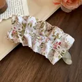 Gros plan d'une pince banane en tissu floral avec détails en zircon et perles - Beige Vert Floral