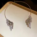 Primo piano di un elegante girocollo dorato con ali di cristallo molto scintillanti - Argento