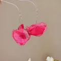 Nahaufnahme der leuchtend rosa Schiffon-Blütenblätter an eleganten Ohrhaken-Ohrringen. - Haken-Stil / Rosa