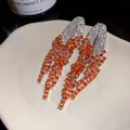 Close-up detail of luxury geometric tassel earrings with brilliant orange rhinestones - Orange (Silver Needle)