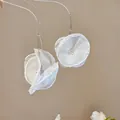 Detailansicht eleganter weißer Chiffon-Blumenohrringe an einem klaren Präsentationsständer - Haken-Stil / Weiß