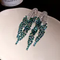 Macro detail of elegant green rhinestone geometric tassel drop earrings for women - Silver Earring Post-Green