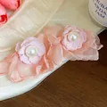 Close-up of pink chiffon flower earrings with central white pearls in soft lighting - Blue/White
