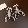 Detailed macro shot of vintage silver metallic lobster statement earrings on leather. - Lobster Shape Earrings / Silver