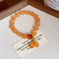 Close-up of orange cat's eye stone beaded bracelet with vintage aesthetic design - Orange Bracelet