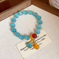 Macro view of light blue cat eye stone bracelet with red and orange accent beads - Bracelet-Blue