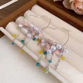 Detailed macro view of heart-shaped hoop earrings with pearls and floral tassels - Heart Tassel Style / Silver - Rainbow