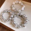 Detailed view of vintage irregular silver beads and pearl bracelets on a cream fabric tray. - Three-Piece Set / Silver