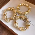 Close-up of three vintage gold irregular geometric beaded bracelets with rustic texture. - Three-Piece Set / Gold