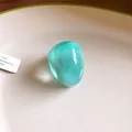Close-up of irregular teal resin wide ring with translucent finish on a plate - Irregular Wide Band Style / Lake Blue