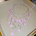 Detaillierte Ansicht der süßen rosa mehrlagigen Perlenkette mit zarten Blumenanhängern - Mehrlagiger Floraler Stil / Rosa