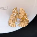 Elegant golden tiered fan-shaped earrings with a metallic pleated finish on a white plate - Silver Post (HE33039) / Gold