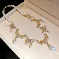 Detailed close-up view of a vintage pearl necklace with elegant rhinestone waterdrop pendants. - Single Necklace / Gold-White