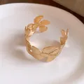 Detailansicht eines goldfarbenen, offenen Blumen-Armreifs mit Vintage-Strukturdesign. - Gold