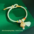 Close-up of a handwoven green silk bracelet featuring a Zongzi charm and tassel detail. - Green