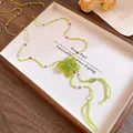 Detailed close-up of a handmade green crystal beaded necklace with a unique flower pendant - Flower Beaded Style / Green