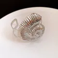 Vue détaillée d'un bracelet manchette coquillage argenté avec une texture plissée. - Argent