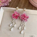 Exquisite close-up of pink silk mesh flower earrings with elegant long pearl tassels - Pink