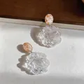 Close-up of resin flower earrings with oval marbled studs for seaside vacation style. - Pale Yellow - Transparent
