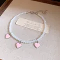 Close-up of beaded anklet with pink heart charms on a textured background - Heart Beaded Style / Pink-Beige