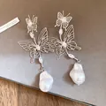 Detailansicht der hohlen Schmetterlingsohrringe mit Zirkonia und Barockperlen - Silberweiß