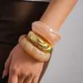 Dettaglio di un set di bracciali rigidi in acrilico marmorizzato e metallo dorato - Set di 3 Bracciali / Confezione da 3 / Impilamento di Colori Misti