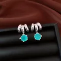 Dettaglio ravvicinato di orecchini argentati a triplo anello con zirconi verde acqua - Argento-Blu