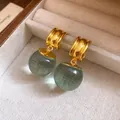 Primo piano di orecchini a cerchio vintage con ciondoli a sfera in resina verde - Verde Pallido