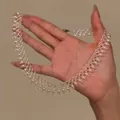 Detailed view of elegant French vintage pearl beaded lace necklace held in hand - White Lace Woven Style / White