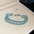 Detailansicht eines eleganten, eisblauen Zirkon-Armbands in einer beigen Schmuckschatulle - Eisblauer Durchbrochener Gewebter Stil (50#)