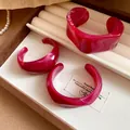 Detail view of stylish irregular geometric marbled resin open cuff bracelets in magenta - Rose Red