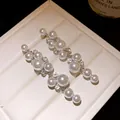 Detailed macro view of elegant silver drop earrings with white pearls and sparkling crystals - Pearl Tassel Studs / Silver