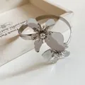 Eleganter silberner Blumen-Armreif mit minimalistischem, gedrehtem Metalldesign - Silber