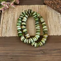 A close-up view of a vintage ethnic shell beaded necklace with multi-tone green beads. - Green