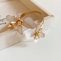Eleganter goldener Armreif mit weißen Emaille-Blumen für Damen, stilvolles Modeschmuck-Accessoire - Gold-Weiß
