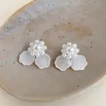 Vista detallada de elegantes pendientes de flores con perlas y pétalos blancos de resina - Perno de plata-Blanco