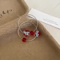 Close-up of dopamine resin hoop earrings featuring blue and red polka dot beads - Hoop-Gold-Red-Blue