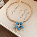 Detailed view of a vintage gold rope necklace with a large blue enamel flower pendant. - Necklace / Blue