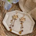 Detailed view of French vintage gold flower earrings with long amber glass bead tassels - Gold Flower with Brown Glass Beads / Pair