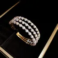 Close-up of triple-layer pearl bracelet with sparkling rhinestone accents in a luxury box - Triple Layer Open Bangle / Gold