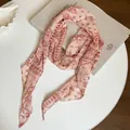 Detail view of a vintage paisley print chiffon scarf in elegant pink and red tones - Pink