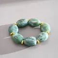 Detailed view of green marble acrylic bracelet featuring gold oval geometric beads - Green