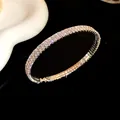 Detalle de cerca de un brazalete de diamantes de imitación en capas sobre fondo negro - Estilo Doble Capa / Plateado