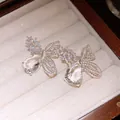 Dettaglio di orecchini a farfalla con zircone a goccia e lavorazione traforata - Stile Farfalla Goccia Cavo (HE34159) / Argento