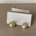 Close-up detail of 18k gold plated drop stud earrings with sparkling star zircon motif - Gold