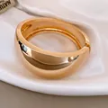 Detailed macro view of a wide shiny gold minimalist bangle with a polished mirror finish - Wide Round Mirror Polish Bangle (1)