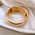 Detailed macro view of a chunky polished gold hinged bangle on elegant white satin fabric - Organic Curve Mirror Polish Bangle (3)