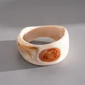 Dettaglio di un bracciale vintage in resina crema con intarsio ovale ambrato - Bianco